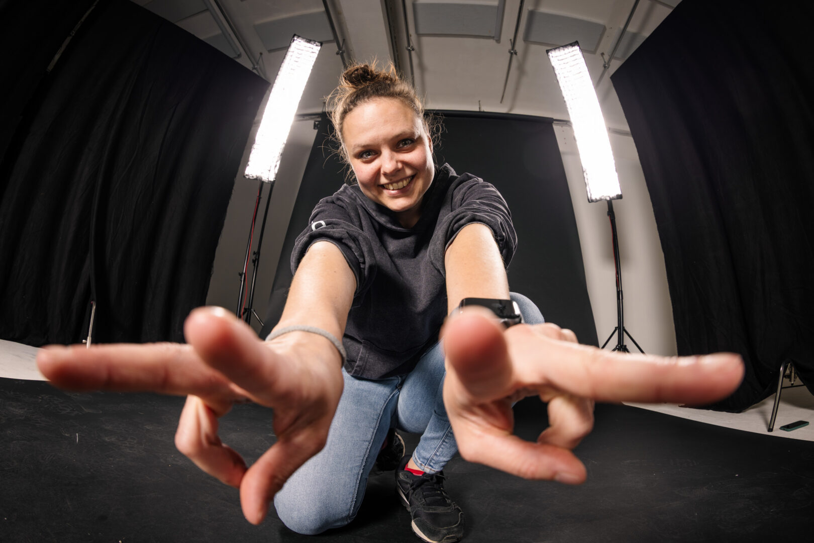 Teammitglied springt vor der Studiowand
